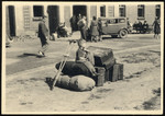 A young child sits among suitcases and a crutch while waiting to depart the Deggendorf displaced persons' camp.