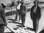Survivors in Ebensee collect the bodies of fellow prisoners for burial.