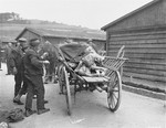 Austrian civilians load corpses onto a cart that will transport the bodies to a mass grave.