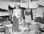 Emaciated female survivors stand beneath hanging laundry in the newly liberated Gunskirchen concentration camp.