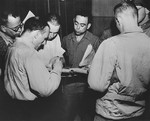 Corporal Jack R. Nowitz (center), a lawyer on the staff of the Judge Advocate General, 3rd U.S.