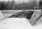 View of the pool in the Ebensee concentration camp where clothing that has been stripped off the dead is being collected.