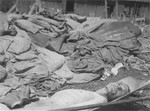 The body of a former prisoner lies outside on a stretcher next to a pile of clothing in the newly liberated Ebensee concentration camp.