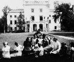 Sister Alma sits on the grass of a convent school in Stara Wies surrounded by four women and six small girls.