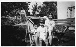 Three Jewish children share a lawn chair.

Pictured are Charlotte and Victor Neumann and their cousin, Erich Butchovits.