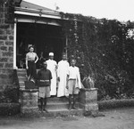 German Jewish refugee Ruth Weyl poses with her African staff on the steps of her boarding house in Nairobi, Kenya.