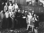 A group of child survivors of Buchenwald pose outside a train that is transporting them to France.