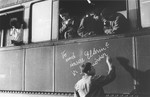 One of the young survivors of Buchenwald writes in German "Where are our parents?" on the side of a train prior to the departure of the children's transport from Buchenwald for France.