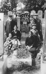 Group portrait of members of an extended Jewish family at the grave of their relative in Piotrkow Trybunalski, Poland.