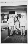 Three chefs aboard the MS St. Louis pose on the deck of the ship.