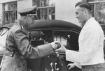 Reichsfuehrer-SS Heinrich Himmler accepts a birthday gift from a server at Hochwald before getting into an automobile.