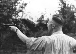 Heinrich Himmler shooting a pistol.