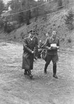 Taken on his birthday, Reichsfuehrer-SS Heinrich Himmler converses with Karl Wolff (right) as they walk along an unpaved road.