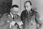Reichsfuehrer-SS Heinrich Himmler looks at a photograph on his birthday with Chief of the Order Police, Kurt Daluege at SS headquarters in Hegewald bei Zhitomir, Ukraine.