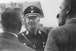 Reichsfuehrer-SS Heinrich Himmler converses with two civilians.