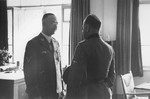 SS-Reichsfuehrer Heinrich Himmler confers with an unknown person in his office at SS headquarters in the Hegewald bei Zhitomir compound.