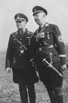 Reichsfuehrer-SS Heinrich Himmler converses with Hans Baur, Hitler's personal pilot outside in a field.
