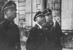 Reichsfuehrer-SS Heinrich Himmler (center) stands outside with Lothar Debes (rights) and another unidentified SS officer.