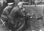 Reichsfuehrer-SS Heinrich Himmler smokes a cigar outside on the grass with Reinhard Heydrich and two other officers during a trip to Estonia.