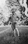 Portrait of Heinrich Himmler standing in a field wearing Lederhosen.