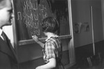 A pupil at the Goldschmidt Jewish private school in Berlin-Grunewald writes the conjugation of the Hebrew verb "to ask" on the chalkboard.