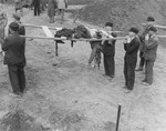 German civilians wait to bury corpses they have carried from the grounds of the Nordhausen concentration camp.