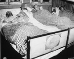 Three survivors infected with typhus lie in beds in the hospital barracks in the Flossenbuerg concentration camp.