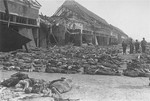 American soldiers stand among hundreds of corpses laid out in rows outside the central barracks (Boelke Kaserne) in the Nordhausen concentration camp.