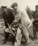 German civilians carry the body of a prisoner from the Nordhausen concentration camp to a mass grave for burial.