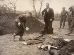 A Polish boy and his father bury the body of the boy's grandmother, who died in the Nordhausen concentration camp.