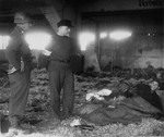 An American soldier and medical officer view the dead and the living in the barracks at the Nordhausen concentration camp.