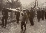 German civilians carry the corpses of prisoners from the Nordhausen concentration camp to a mass grave for burial.