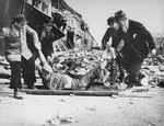 German civilians from the town of Nordhausen removing the corpses of prisoners for burial in a mass grave.