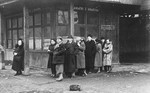 Jews wait in line on a streetcorner in the Krakow ghetto.