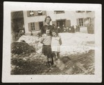 Frieda Johles poses with her mother, Malka Johles and a friend outside the main building of the Morgins family camp which housed the adults.