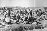 Serbian women and children from the Kozara region who have been deported from their homes, sit outside at the Daruvar concentration camp.