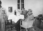 Vjekoslav Luburic sits at a table with a German officer in the Stara Gradiska concentration camp.