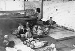 Young children resting on the floor in a barracks at the Sisak concentration camp for children.