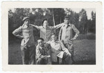 Portrait of five young survivors of the Buchenwald concentration camp in their uniforms.