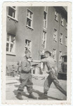 Two young survivors play fight outside a building in the liberated Buchenwald concentration camp.