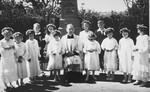 A Jewish child in hiding stands among a group of Polish children dressed up for their First Communion.
