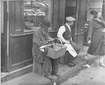 A Jew sells peanuts in front of a bakery in the Jewish quarter of Paris.