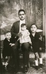 Portrait of the Mordo family in Corfu.

Pictured are Jacob Mordo and his three children: Perla (the infant on her father's knee), Moses (left) and another son (right).