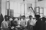 DPs working in food distribution at the Ziegenhain displaced persons' camp pose in a warehouse.