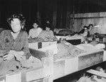 Female survivors of the Mauthausen concentration camp lie in wooden bunks in the hospital barracks.