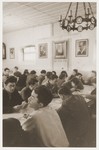 Members of Kibbutz Nili hachshara (Zionist collective) in Pleikershof, Germany, sit around tables in the dining hall.
