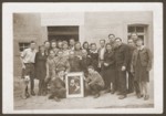 Group portrait of members of the Zettlitz hachshara with a framed picture of Theodor Herzl.