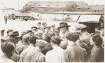 Members of the Kibbutz Nili hachshara (Zionist collective) in Pleikershof, Germany crowd around an American official and his entourage during a tour of the settlement.