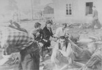 Survivors in Bergen-Belsen rest outside a barrack.
