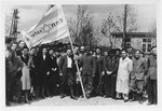 Members of the PHH (Partizanim-Hayyalim-Halutzim) gather alongside their banner in the Zeilsheim displaced persons' camp.